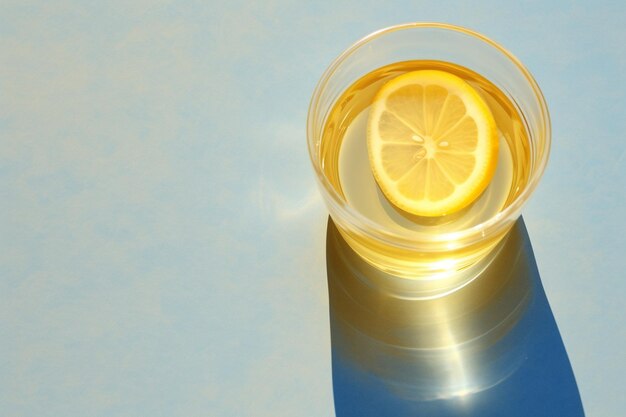 A close-up shot of lemon slices floating in a glass of water, with natural sunlight filtering through, creating a refreshing and healthy vibe.