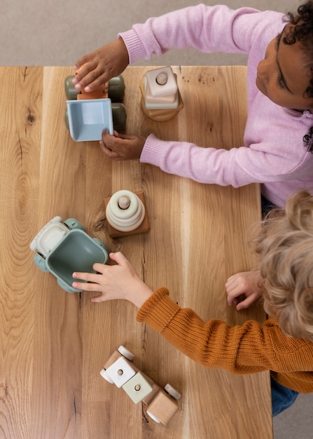 A group of young children (ages 6-8) sitting around a table, intently focused on assembling and programming a brightly colored LEGO robotics kit. The atmosphere is energetic and collaborative, showcasing a fun and engaging learning environment.