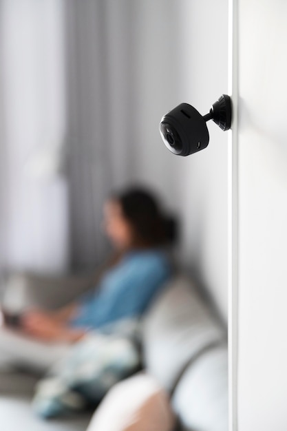 A close-up shot of an AI-powered security camera recognizing and differentiating between a family member and a stranger, using facial recognition technology. The camera is sleek and modern, seamlessly blending into the home's interior.