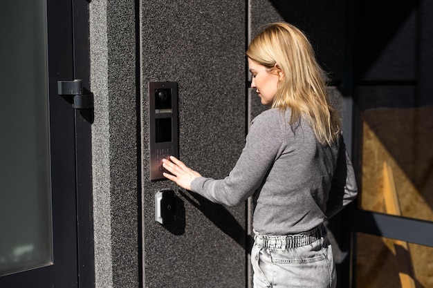 A modern front door featuring a biometric lock that scans a person's fingerprint. The door is sleek and minimalist, with the biometric scanner seamlessly integrated into the door handle.