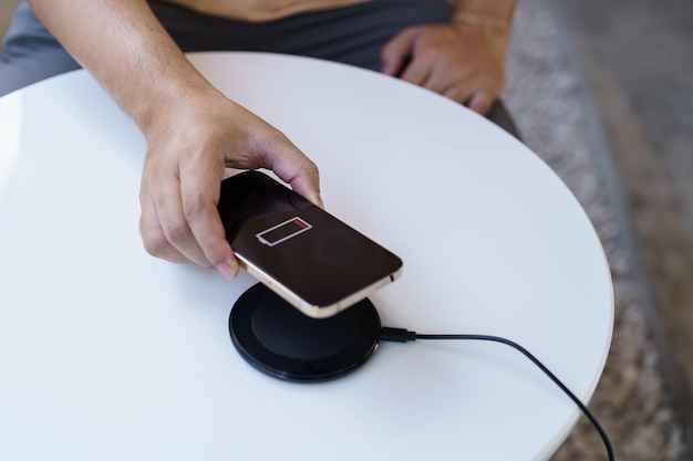 A close-up shot of a wireless charger using magnetic resonance to charge multiple devices at varying distances, showcasing the technology's potential.