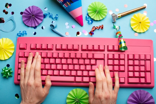 An overhead shot of a person carefully replacing keycaps on a mechanical keyboard with a keycap puller, showcasing a variety of colorful and uniquely designed keycaps laid out on a soft mat.