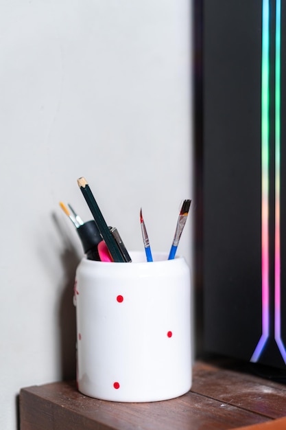 A close-up shot of a multi-functional pen, showcasing its different components like a pen, ruler, screwdriver, and level. The background is a blurred desk with stationery.
