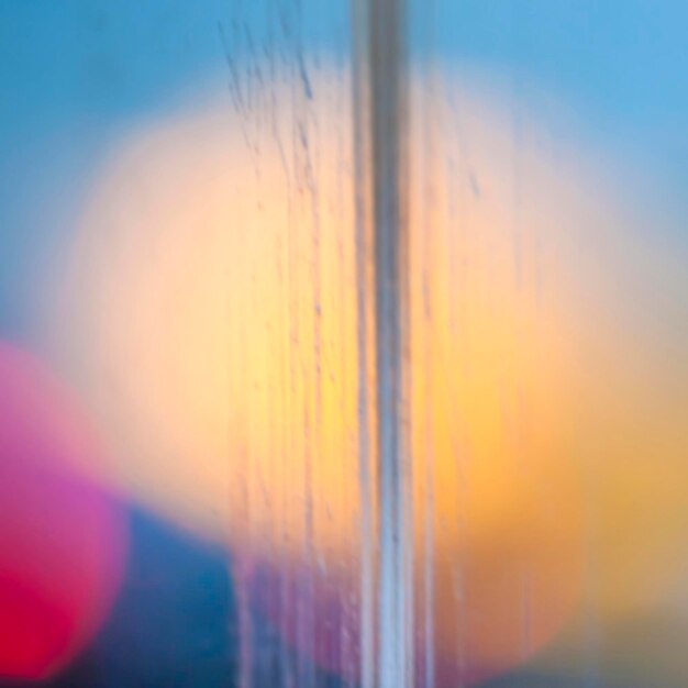 A close-up, detailed illustration showing sunlight entering a raindrop, then refracting, reflecting internally, and refracting again to exit and separate into different colors, labeled with arrows and scientific names.