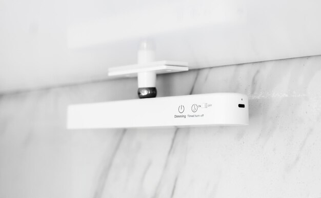 A photo of a modern electric showerhead in a contemporary bathroom, showing the digital temperature display, sleek design, and the water stream. The background is blurred to highlight the showerhead.