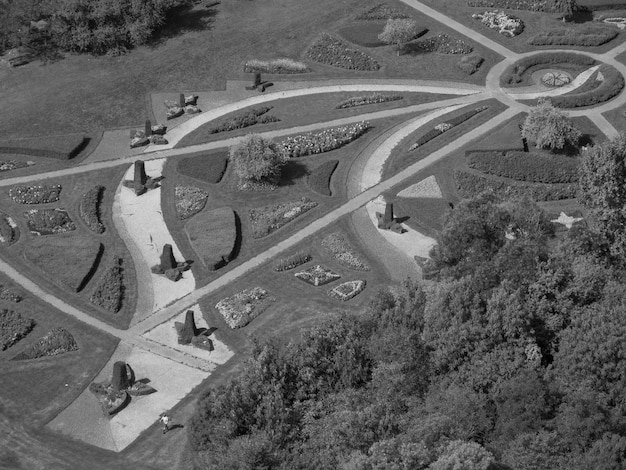A black and white aerial view depicting the iconic airplane shape of the Plano Piloto in Brasilia, showing the division between the residential and monumental axes, and the surrounding landscape.