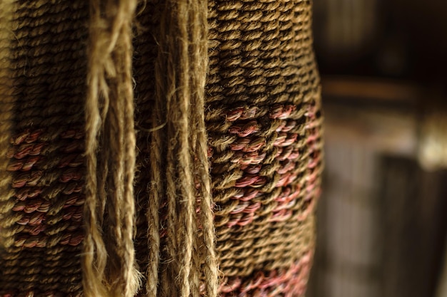 A close-up shot of intricate indigenous Brazilian craftsmanship, focusing on the detailed weaving patterns in a basket and the vibrant colors of a hammock. The image highlights the traditional techniques and the cultural significance embedded in these handmade objects.